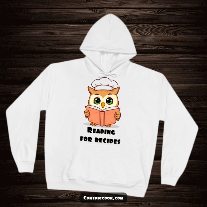 Funny curious owl chef peering into a cookbook with wide eyes, depicted on a soft and warm hoodie for cozy contemplation.